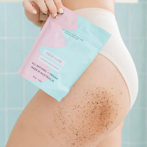 Female holding BodyBlendz Package in front of her hip with coffee scrub on her thigh