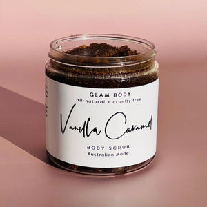 an open clear jar with a grainy brown scrub inside on a pink background