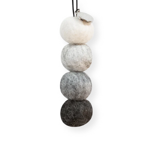 four tonal grey to white felt balls hanging