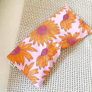 Pink, Purple and Yellow Sunflower design heat pack on neutral knitted fabric background