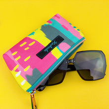 Load image into Gallery viewer, unzipped pink, yellow, aqua fabric all purpose zip pouch with sunglasses 
