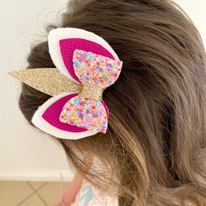 Handmade Unicorn Hair Accessory Alligator Clip with Gold glitter unicorn horn and rainbow glitter bow. Modelled in a 4 year old's hair