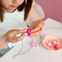 Load image into Gallery viewer, little girl beading a necklace with pink beads
