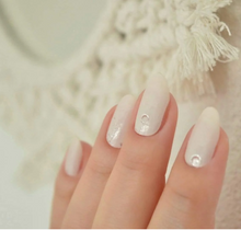 Load image into Gallery viewer, Nail wraps with a nude pink and celestial design on nails with macrame in the background
